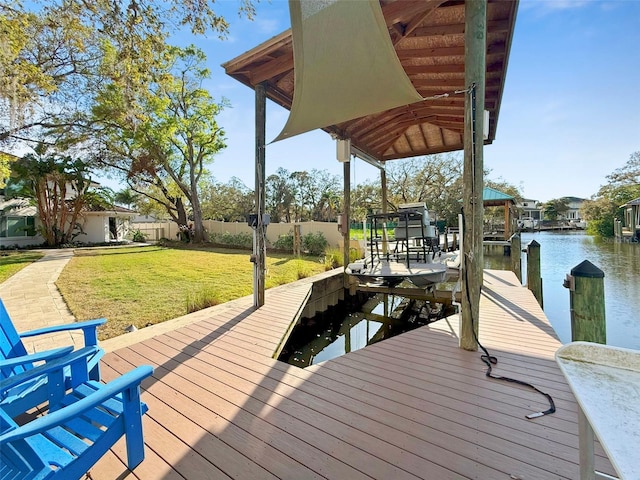 dock area featuring a yard, a water view, boat lift, and fence