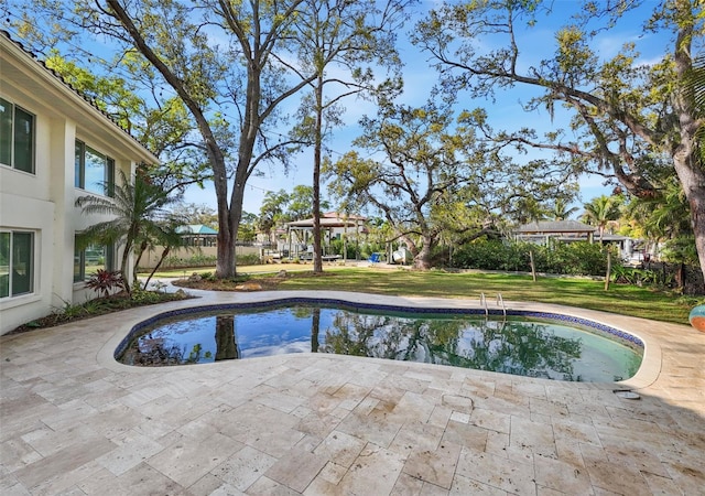 view of swimming pool with a patio and a yard