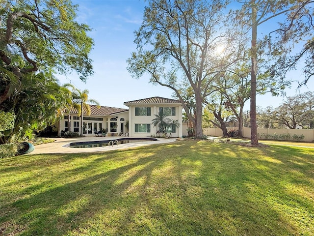 rear view of house with a patio, fence, a lawn, and stucco siding