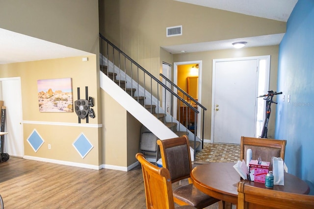 interior space featuring high vaulted ceiling, wood finished floors, visible vents, and baseboards