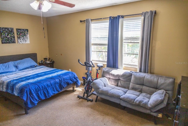 bedroom featuring carpet floors, a textured ceiling, and a ceiling fan