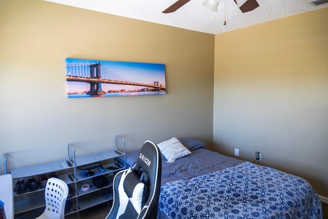 bedroom featuring a ceiling fan, visible vents, a water view, and a textured ceiling