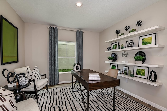 home office featuring baseboards, a textured ceiling, and wood finished floors