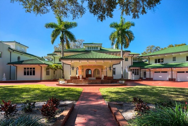 back of property featuring stucco siding, a lawn, and a tiled roof