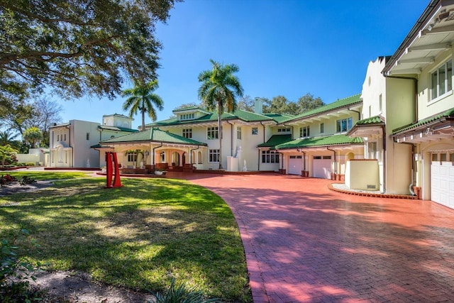 view of front of property featuring an attached garage, driveway, and stucco siding