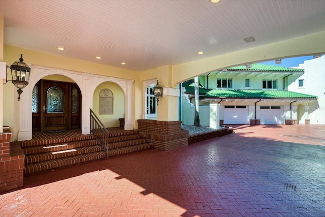 exterior space featuring a porch, decorative driveway, a garage, and stucco siding
