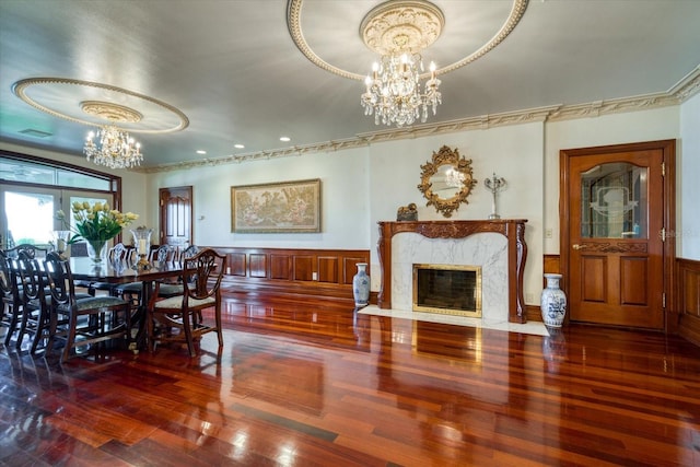 dining space with a chandelier, a wainscoted wall, and wood finished floors