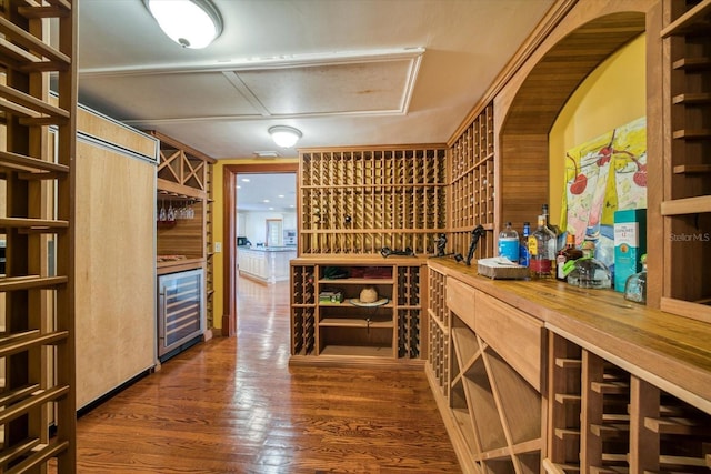 wine cellar with wood finished floors and beverage cooler