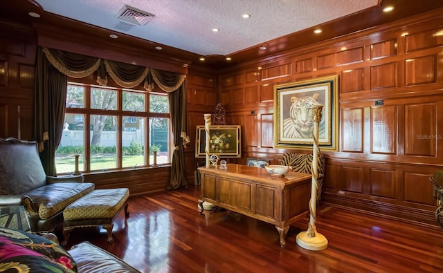 office area featuring visible vents, wooden walls, dark wood-style floors, and a textured ceiling