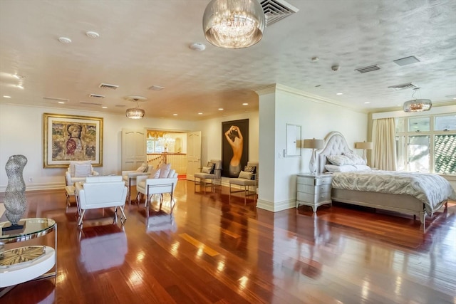 bedroom featuring visible vents, a notable chandelier, wood finished floors, and a textured ceiling