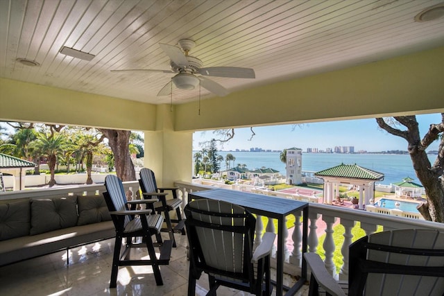 view of patio with a ceiling fan and a water view