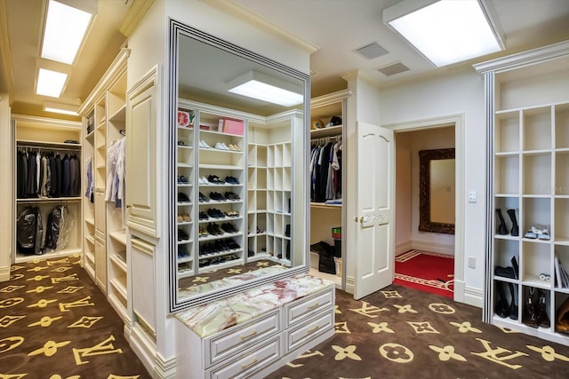 walk in closet featuring visible vents and dark carpet