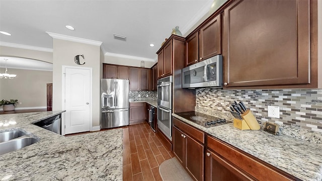 5324 Moon Shell Dr, Apollo Beach, FL 33572 - kitchen featuring stainless steel appliances, crown molding, backsplash, light stone counters, and a chandelier