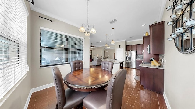 5324 Moon Shell Dr, Apollo Beach, FL 33572 - dining room with healthy amount of natural light, crown molding, a chandelier, baseboards, and dark wood-style flooring