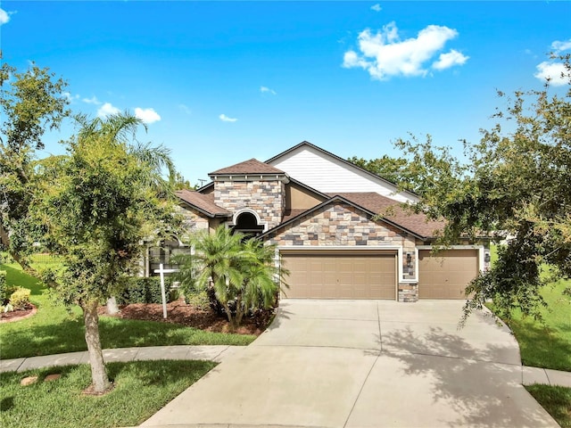5324 Moon Shell Dr, Apollo Beach, FL 33572 - view of front of property featuring stone siding, an attached garage, driveway, and a front yard