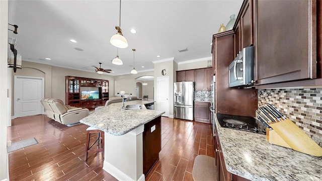 5324 Moon Shell Dr, Apollo Beach, FL 33572 - kitchen with stainless steel appliances, a sink, ceiling fan, arched walkways, and dark wood-type flooring