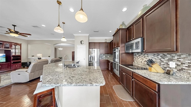 5324 Moon Shell Dr, Apollo Beach, FL 33572 - kitchen featuring stainless steel appliances, arched walkways, crown molding, a sink, and wood finish floors