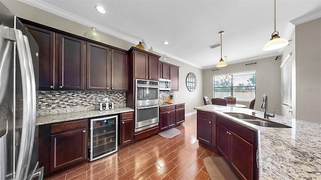 5324 Moon Shell Dr, Apollo Beach, FL 33572 - kitchen featuring stainless steel appliances, wine cooler, a sink, ornamental molding, and tasteful backsplash