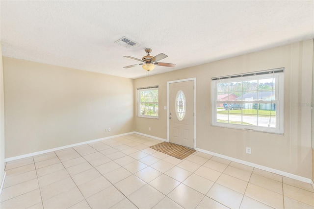 entryway featuring baseboards, a ceiling fan, visible vents, and a textured ceiling