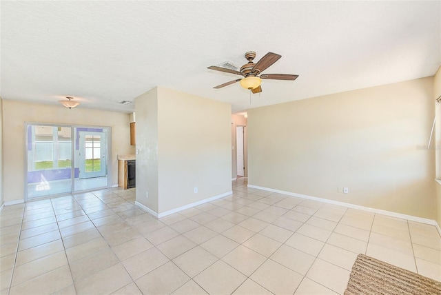 unfurnished room with light tile patterned floors, baseboards, and ceiling fan