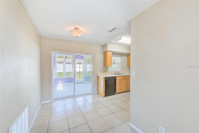 kitchen featuring visible vents, dishwasher, light countertops, and a sink