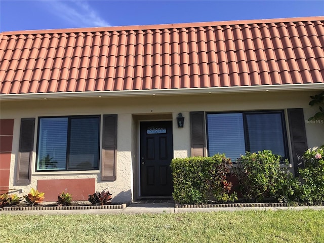 view of property featuring stucco siding and a tiled roof