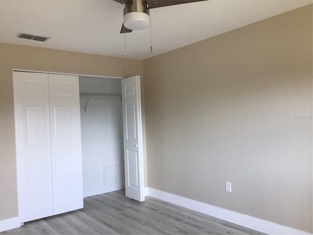 unfurnished bedroom with a ceiling fan, visible vents, baseboards, a closet, and light wood-type flooring