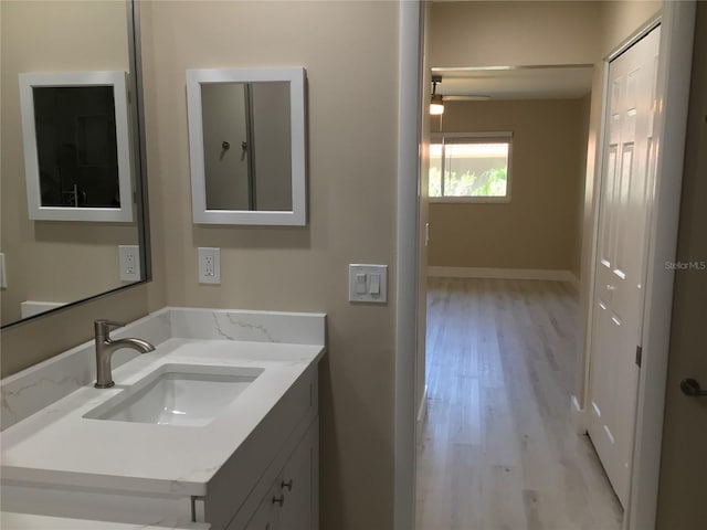 bathroom with vanity, baseboards, and wood finished floors