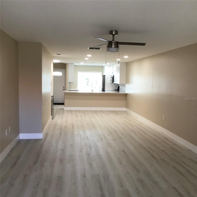 unfurnished living room with recessed lighting, a ceiling fan, baseboards, and light wood finished floors