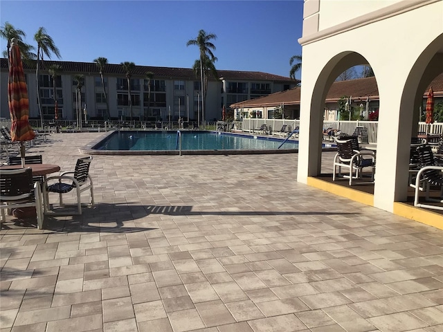 pool with a patio area and fence