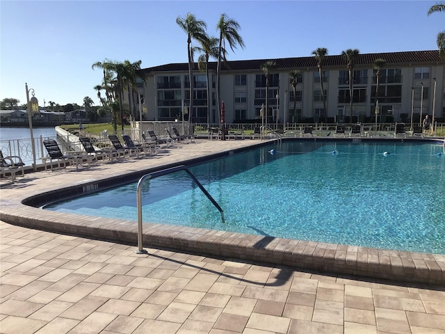 community pool with fence and a patio area