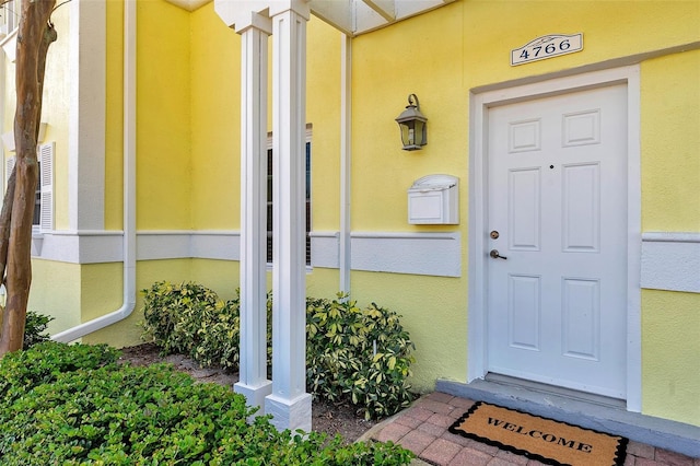 entrance to property featuring stucco siding