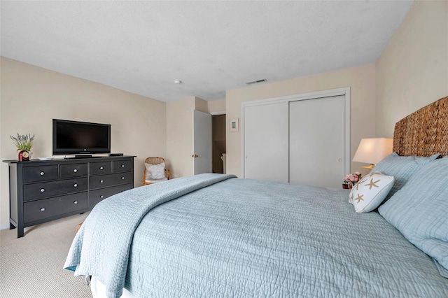 bedroom featuring light carpet, visible vents, and a closet