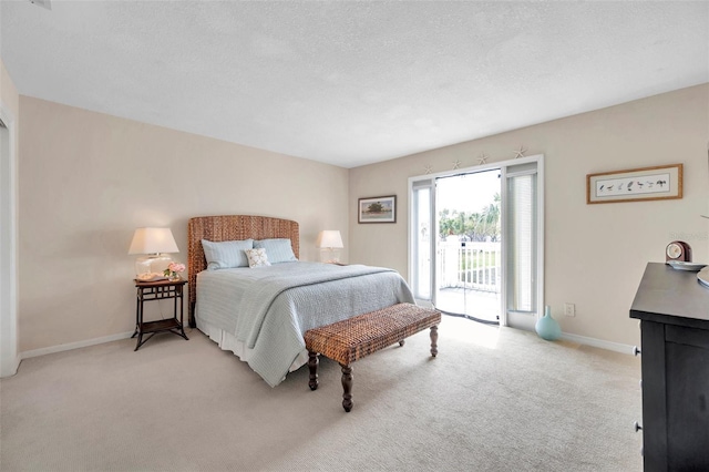 carpeted bedroom featuring access to outside, baseboards, and a textured ceiling