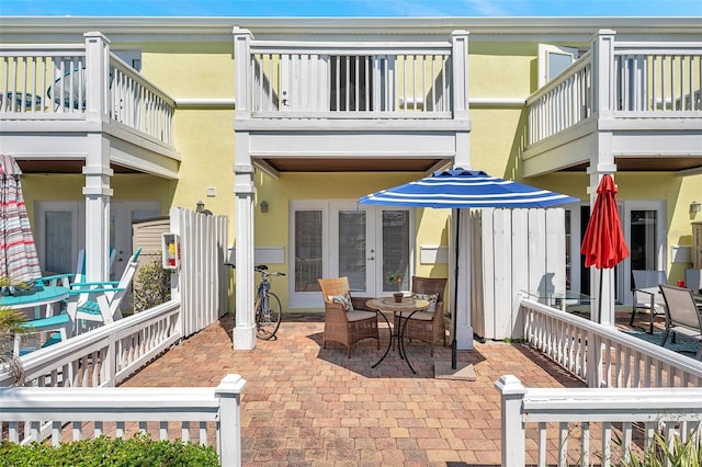 rear view of property featuring stucco siding, a patio, and outdoor dining area