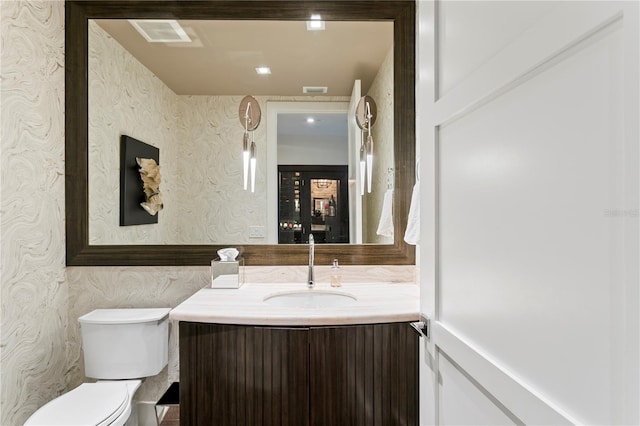146 4th Ave NE Unit 600, Saint Petersburg, FL 33701 - half bath with wallpapered walls, visible vents, toilet, and vanity