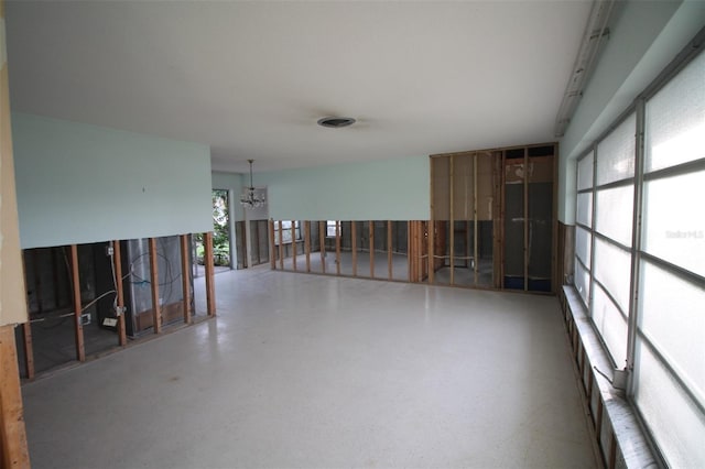 empty room with visible vents and a chandelier