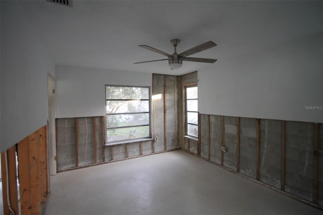 unfurnished room featuring concrete floors and a ceiling fan