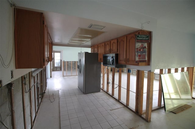 kitchen with brown cabinets, appliances with stainless steel finishes, and light tile patterned flooring