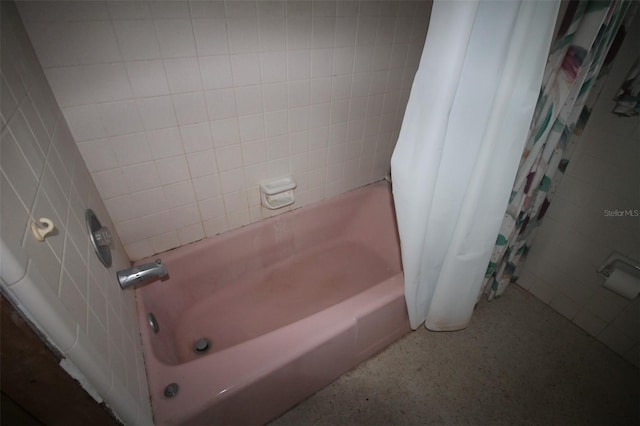 bathroom with tile walls, speckled floor, and shower / tub combo