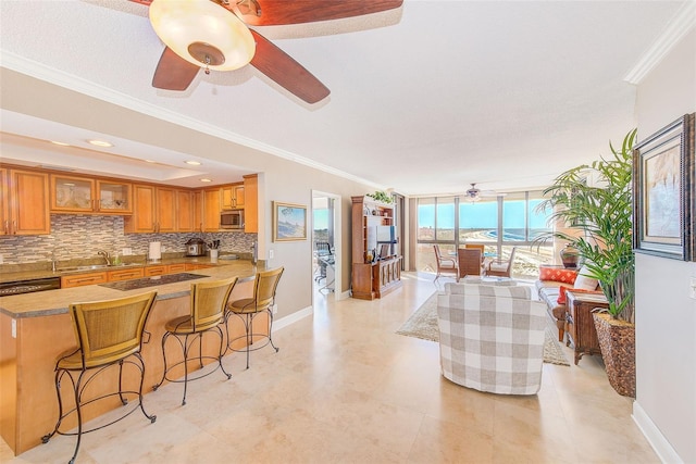 kitchen with decorative backsplash, stainless steel microwave, a ceiling fan, and crown molding