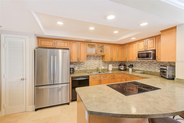 kitchen with decorative backsplash, a peninsula, black appliances, a raised ceiling, and a sink