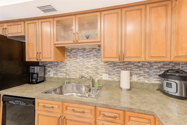 kitchen featuring visible vents, dishwasher, light countertops, decorative backsplash, and a sink