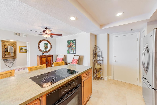 kitchen with a ceiling fan, visible vents, freestanding refrigerator, wall oven, and black electric stovetop