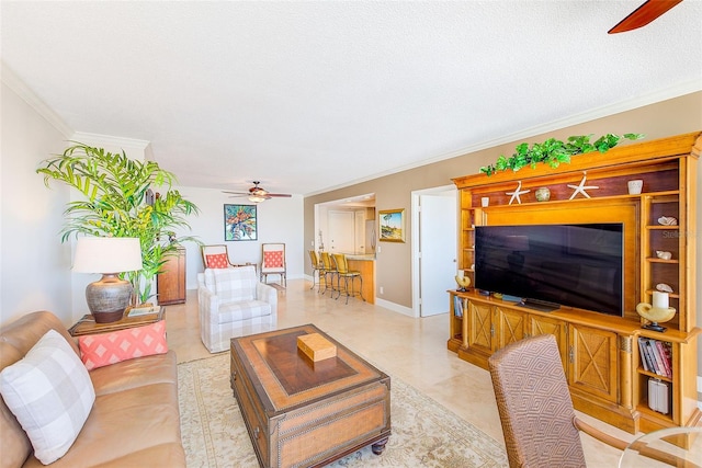 living area featuring baseboards, crown molding, and ceiling fan