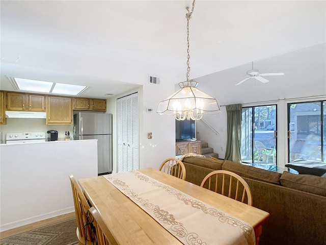 dining space featuring visible vents, dark wood-style floors, ceiling fan, and stairway