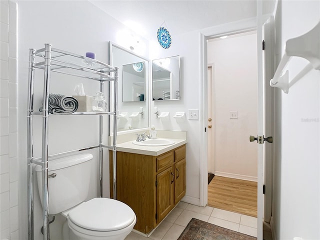 bathroom featuring tile patterned floors, toilet, vanity, and baseboards