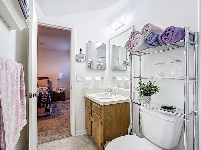 bathroom with connected bathroom, toilet, and vanity