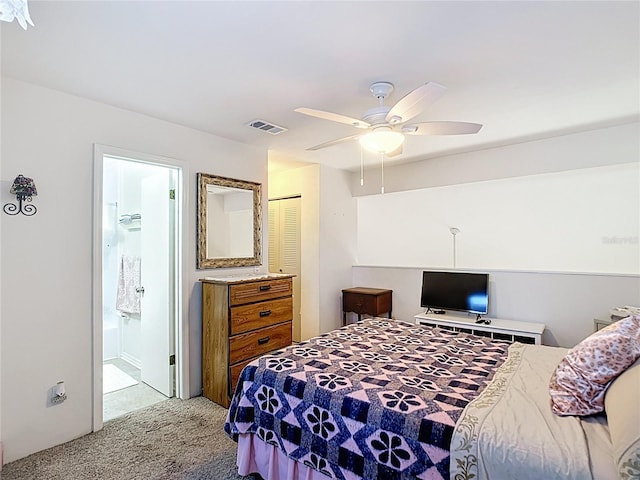 carpeted bedroom with ensuite bath, visible vents, and ceiling fan