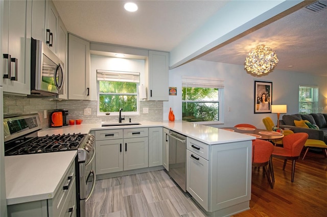 kitchen with visible vents, open floor plan, light countertops, appliances with stainless steel finishes, and a peninsula